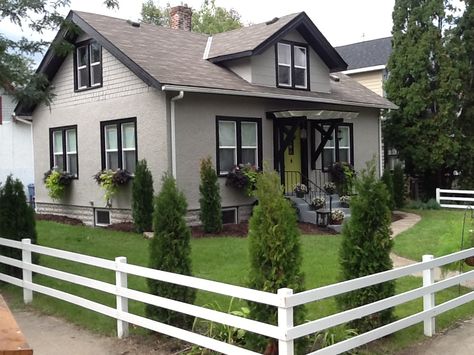 Remodeled 1918 craftsman home, black trim, taupe exterior (cliffside from Ace), citron green door, white 3 rail fencing, charming window boxes, love it! House Black Trim, Black Trim Exterior House, White Window Trim, Black Window Trims, Colors For House, Paint Colors For House, Gray House Exterior, House Green, House Trim