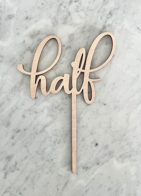 "This listing is for an adorable half birthday cake topper! Made with laser-cut  1/8\" maple plywood.  Approximate size is 6\" wide. Skewer portion is 5\" long. Photos show cake topper on an 8 inch round cake. Please note - due to natural variation in wood, coloration may slightly  vary. Please include event date at checkout to ensure timely delivery.  Shipping: I typically ship items within 1-2 business days. Approximate shipping time is between 3-7 business days, but USPS does not guarantee da Half Birthday Decor, 6 Month Birthday Cake, Half Birthday Cake, 6 Month Birthday, Long Photos, Half Birthday Cakes, Donut Themed Birthday Party, Wood Cake Topper, Wood Cake