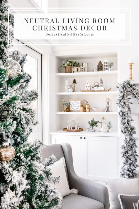 A Neutral Living Room Christmas Decor home tour with flocked garland, a flocked Christmas tree, and a cozy glider by the fireplace to snuggle up in and read Christmas stories. | Two-story living room decorations. | White living room Christmas decorations. | White built-ins with Christmas decorations. | How to decorate bookshelves for Christmas. | Two-story fireplace decor. | Christmas garland on a fireplace mantel. | Large mirror above a fireplace. | Simple Christmas decor. Built In Christmas Decorations, Neutral Pink Christmas Decor, Fireplace Built Ins Christmas Decor, Christmas Decor Ideas Built Ins, Built Ins Decorated For Christmas, Winter Built In Decor, Christmas Fireplace Shelves Decor, Christmas Decor Ideas For Built Ins, Built In Shelf Christmas Decor