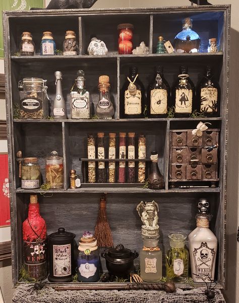 Potions cabinet with Harry Potter themed ingredients Potion Display Halloween, Witch Potion Shelf, Snapes Potion Room, Harry Potter Magic Potions, Potion Ingredients Harry Potter, Potion Bottle Decorations, Apocathary Decor, Potion Bottle Display, Harry Potter Ingredients