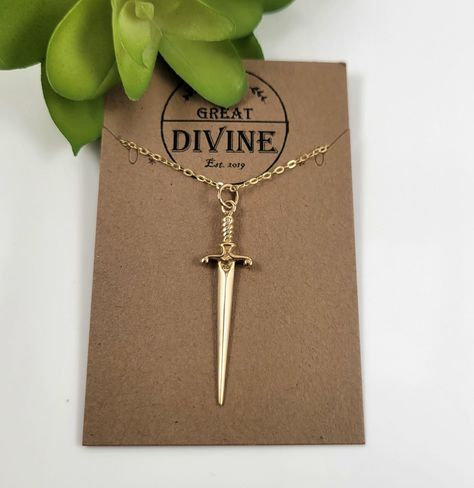 🚚 Spend $35+ to Unlock Free Shipping! (US residents Only)🚚 ~ All Gold Sword Necklace~ ❇️ Type: Charm/Pendant ❇️ Pendant Size: 25X19MM ❇️ Chain Lengths: 16" or 18" ❇️ Chain Options: 14K Gold Filled or Sterling Silver ❇️ Charm Material: Sterling Silver and Premium Bronze with anti-tarnish properties ❇️ Style: Dainty Pair this Cute Sword Charm Necklace with our Matching Mini Sword Earrings: https://www.etsy.com/listing/1656042390/mini-sword-earrings-huggie-sword Gold Dagger Necklace, Mikasa Costume, Bookish Jewelry, Xoxo Jewelry, Dagger Necklace, Gold Charm Necklace, Bookish Gifts, Stunning Jewellery, Jewelry Inspo