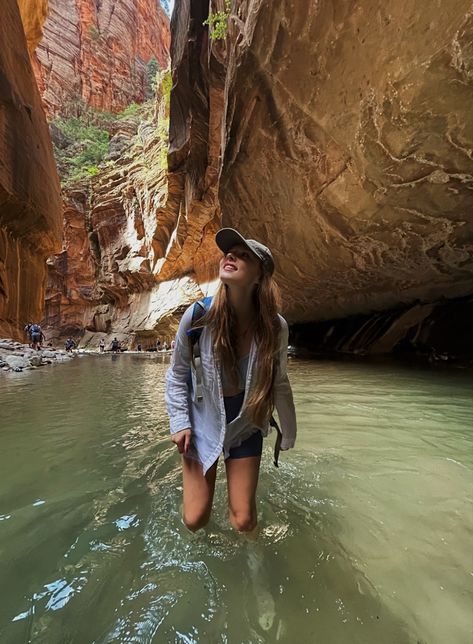 Girl hiking through water in Zion national park looking up smiling Zion National Park Poses, Zion Hiking Outfit, Zion National Park Outfit, Arizona Outfits Summer, Arizona Hiking Outfit, Fall Camping Outfits, Outdoor Fits, Hiking Picture Ideas, Camping Outfits For Women Summer