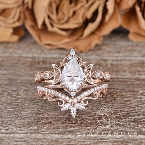 Unique Pear Shaped Moissanite Engagement Ring Set 2PCS Rose Gold Marquise Wedding Band Women Moon Ring Vine Flower Ring Bridal Set Milgrain * Ring Material: solid 14k rose gold, yellow gold and white gold  * Center Stone: Colorless Moissanite, in Pear  * Center Stone Size: 6x8mm / 1.2ct  * Side Stone: Natural Diamond or Moissanite, about 0.2ct * Bandwidth: 1.5mm * Buy them separately:  Engagement ring: https://www.etsy.com/listing/1588933506 2-3 WEEKS PROCESSING TIME MADE IN US * Shipping * FREE Moissanite Bridal Ring Sets, Vintage Black Wedding Ring, Nested Wedding Band, Vintage Pear Ring, Pear Shape Rings, Engagement Rings Teardrop, Wedding Rings Engagement Gold, Gold Marquise Wedding Band, Unique Pear Engagement Ring