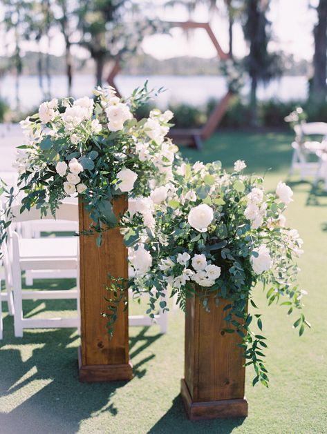 White and Green Floral Altar pieces in a garden style atop of natural wood stands. Wedding Aisle Columns, Floral Stand Wedding Ceremony, Wedding Ceremony Column Flowers, Ceremony Arrangements On Pedestals, Wedding Flowers On Pedestal, Standing Floral Arrangements Wedding, Floral Arrangements On Pedestals, Ceremony Flower Stands, Nature Wedding Ceremony Decor