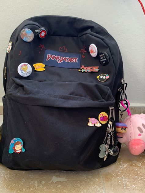 Decorated Jansport Backpack, Jansport Bag With Pins, Jansport Decoration Ideas, Black Backpack With Pins, Jansport Bag Aesthetic, Bagpack Decorating Ideas, Black Jansport Backpacks Aesthetic, Travel Backpack Aesthetic, Black Backpack Aesthetic