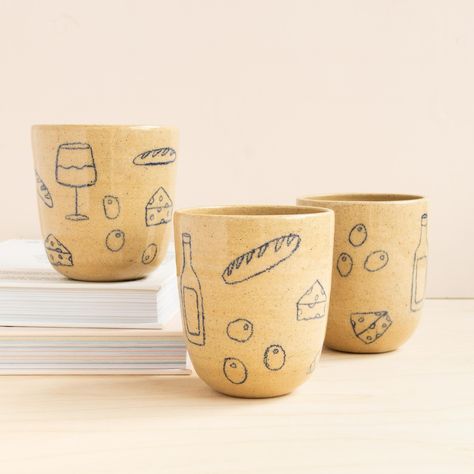 “Girl Dinner” cups by local artist @earthandherflower with hand drawn designs in underglaze pencil and a clear coat for easy cleaning. 🥖 🍷 Underglaze Pencils Ceramics, Underglaze Pencil Pottery, Ceramic Cup Ideas, Underglaze Ideas, Underglaze Designs, Underglaze Pencil, Clay Classes, Painted Ceramics, Pottery Inspo