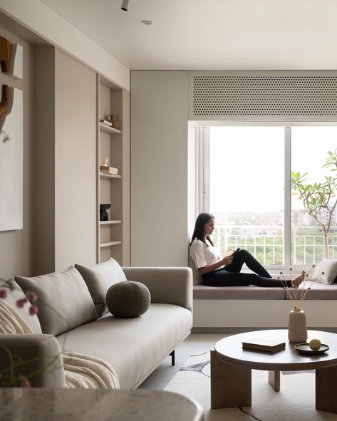 In this serene living room, the low-profile, relaxed furniture emphasizes visual spaciousness, allowing the space to breathe. A custom-designed window seat offers a peaceful lounging spot with stunning sunset views, while cleverly integrating storage on both ends. The sofa, center table, and pouffe were custom designed by us. Whereas the thoughtful shelving that incorporates structural columns blend function with style. Principal Designers - @saniya_jejani @loharsagar Design Team - @s1ddhan... Serene Living Room, Sofa Center Table, Sofa Center, Stunning Sunset, Sunset Views, Window Seat, Center Table, Low Profile, Living Room Designs