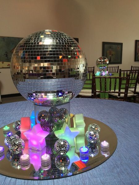 These mirror ball centerpieces were created for a disco-themed Bat Mitzvah. We used rotating-color stars and LED lights so that the colors of the centerpieces were constantly changing. Under the dimmed evening light, they looked very cool indeed!More Social Events...<<Back to… Disco Theme Parties, Festa Rock Roll, Bat Mitzvah Centerpieces, Mitzvah Centerpieces, Disco Theme Party, 70s Party Theme, 70s Theme Party, 70s Disco Party, Disco Birthday Party