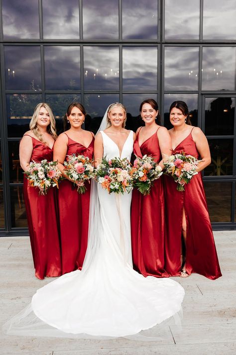 Bridesmaids in matching red satin bridesmaid dresses with leg slit posing with the bride with her curled blonde hair in sleek hairstyle with fitted wedding dress Light Red Bridesmaid Dresses, Red Bridesmaid Dresses Summer, Bridesmaid Red Dresses, Red Satin Bridesmaid Dresses, Red Bridesmaids Dresses, Doughnut Tower, Bridesmaid Dresses Red, Bridesmaid Dresses Red Long, Cave Wedding