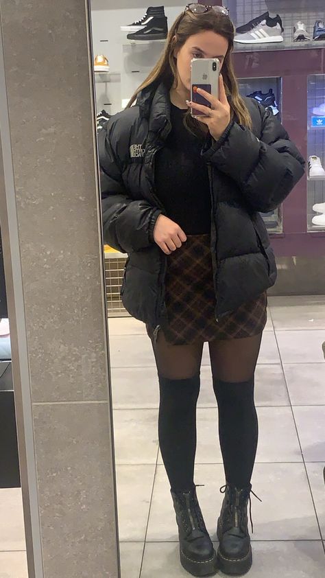 Dr martens plaid skirt knee high socks north face puffer Plaid Skirt Knee High Socks, Over Knee Socks Outfit Winter, Fits With Dr Martens, Puffer And Skirt Outfit, Cute Knee High Socks Outfits, Puffer Jacket With Skirt Outfit, Dr Martens With Socks, Skirt And High Socks, Outfits With Knee Socks