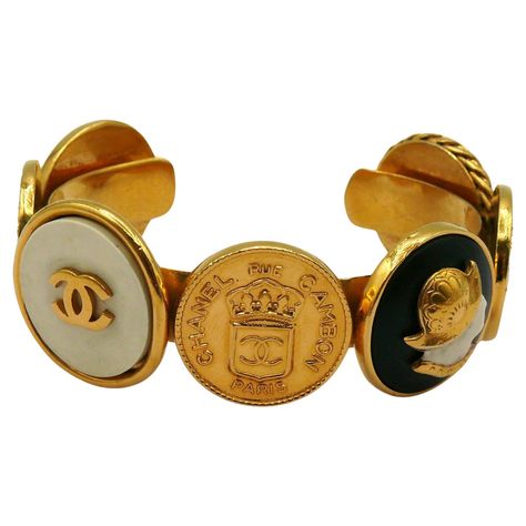 CHANEL vintage iconic gold tone bangle bracelet featuring coins : Crowned CC CHANEL 31 Rue Cambon Paris, Elephant, Helmeted Guards, CC logos and a Lady profile. Embossed CHANEL. Indicative measurements : inner measurements approx. 5.9 cm x 4.6 cm (2.32 inches x 1.81 inches) / max. width approx. 2.4 cm (0.94 inch) / wrist opening approx. 2.6 cm (1.02 inches). Material : Gold tone metal hardware / Resin. Comes with the original CHANEL box (very used vintage condition). NOTES - This is a preloved vintage item, therefore it might have imperfections. - Colors may differ slightly from actual product appearance due to differences in lighting conditions. - As a buyer, you are fully responsible for customs duties, other local taxes and any administrative procedures related to imports into the count 31 Rue Cambon, Vintage Chanel Jewelry, Chanel Box, Chanel Vintage, Chanel Jewelry, Vintage Chanel, A Lady, Arm Candy, Metal Hardware