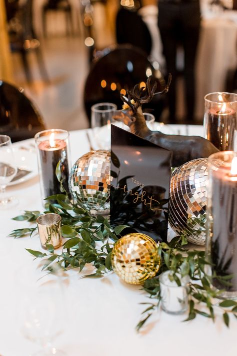 Black and White Wedding Decor with Silver and Gold Disco Ball Decor and Greenery | Black Acrylic Table Number Signs Wedding Centerpieces With Disco Balls, Black White Gold Gala Decor, Disco Ball Wedding Centrepiece, New Year’s Eve Wedding Table Decor, Gold And Black Table Decorations, Gold Disco Ball Decor, Black And White Photo Centerpieces, Disco Greenery Wedding, Glitz And Glam Centerpieces