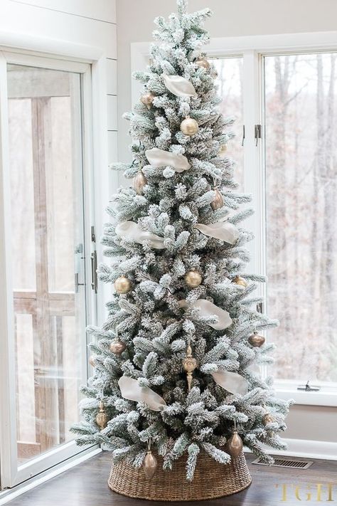 White flocked Christmas tree with basket tree collar. Neutral Christmas tree decorations and ideas. Gold and rose gold Christmas tree ornaments. Artificial flocked Christmas tree. #christmastree #flockedtree #holidaydecor Christmas Living Room Decorating Ideas, White Flocked Christmas Tree, Rose Gold Christmas Tree, Christmas Colour Schemes, Flocked Christmas Tree, Silver Christmas Decorations, Flocked Christmas Trees Decorated, Christmas Living Room, Tree Collar