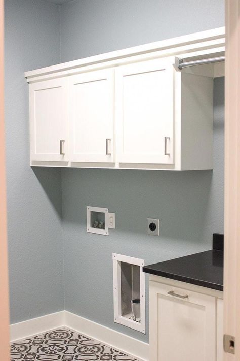 A laundry room with blue walls, white cabinets, and gray tile floor. #laundryroombasement Gray Tile Floor, Room With Blue Walls, Grey Tile Kitchen Floor, Room Tiles Design, Grey Kitchen Tiles, Blue Kitchen Walls, Laundry Room Paint Color, Laundry Room Paint, Grey Laundry Rooms