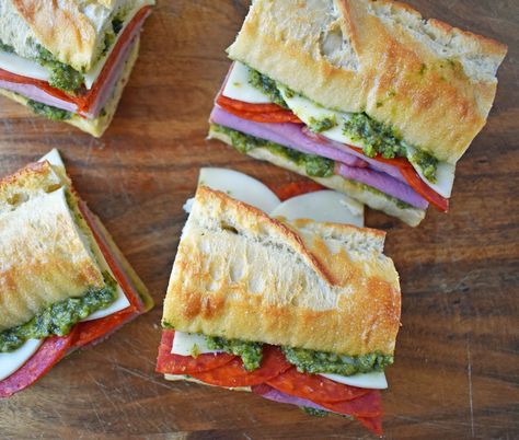 Italian Pressed Sandwiches made with rustic French bread layered with Italian meats and cheeses, pesto sauce or olive oil and vinegar, and marinated tomatoes. This Italian Pressed Sandwich with pesto sauce is perfect for a picnic, kids lunch, or for a casual lunch. www.modernhoney.com Pressed Sandwiches, Make A Sandwich, Summer Picnic Food, French Bread Loaf, Modern Honey, Rolled Sandwiches, Pressed Sandwich, Pesto Sandwich, Marinated Tomatoes