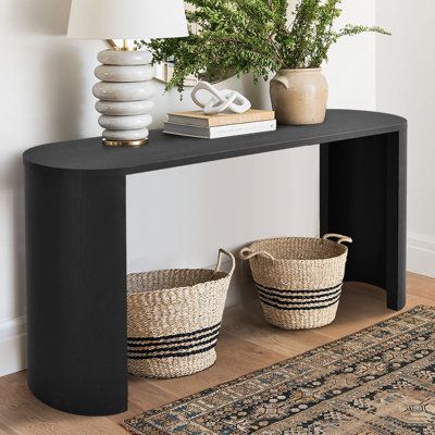 Versatile in design, this console table is here to bring a visually stunning accent to any room. It has an engineered wood frame with a solid finish, and it features two curved legs that you can install facing in or outward depending on your preference. The oval table top measures 60" wide, giving you plenty of space for vases, lamps, and other decor. Slide it up behind your living room sofa or against the wall in your entryway to curate a more modern look. Wade Logan® Color: Black | Wade Logan® Black Console Table Decor, Black Entryway Table, Black Console Table, Console Table Decorating, Oversized Furniture, Foyer Table, Black Console, Modern Console Tables, Modern Console