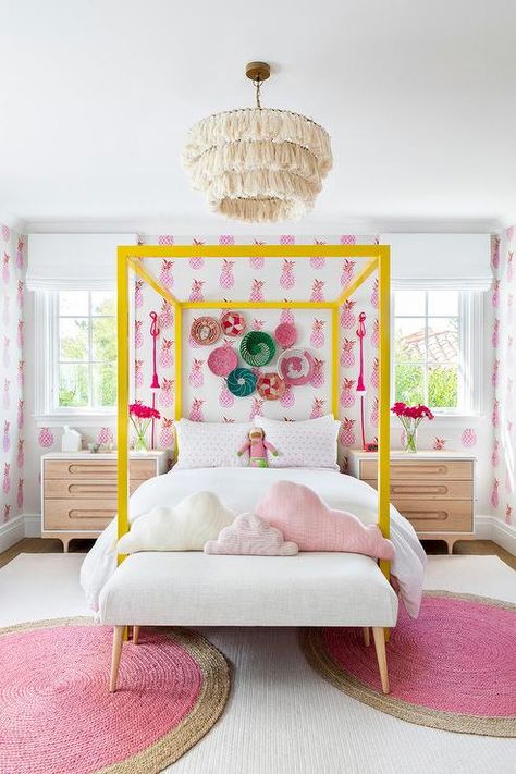 Decorative baskets hang from a wall cover in pink pineapple wallpaper over a yellow canopy bed accented with white and pink bedding. White And Pink Bedding, Twin Canopy Bed, Yellow Decor, Girl’s Room, Bed Sets, Pink Bedding, Big Girl Rooms, Teen Bedroom, Girls Room Decor