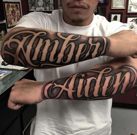 Choosing the right font style for your script tattoo as a man can be quite an uphill task. Whether you want a flashy design or a simple minimalistic look, you will be spoilt for choice with the thousands of options available. These twin tattoos say ‘Amber’ on one arm and ‘Aiden’ on another. They are represented in large cursive fonts to add formality. The twin tattoos obviously represent a couple and the typeface is common among tattoo fonts ideas. Forearm Script Tattoo, Tattoo Writing Styles, Last Name Tattoos, Tattoo Bras Homme, Tattoo Name Fonts, Font Tato, Tattoo Font For Men, Outer Forearm Tattoo, Names Tattoos For Men