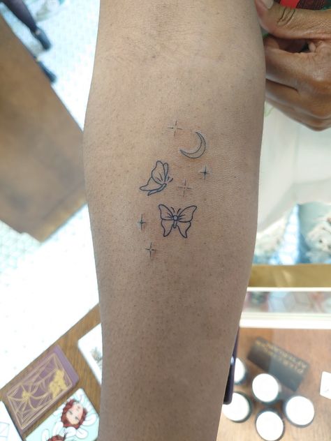 Lined butterflies tattoo with moon and stars Moon Star Butterfly Tattoo, Butterflies With Stars Tattoo, Butterfly Moon Stars Tattoo, Dainty Earthy Tattoos, Small Lower Arm Tattoos For Women, Space Butterfly Tattoo, Butterfly And Star Tattoo, Butterfly And Stars Tattoo, Moon And Butterfly Tattoo