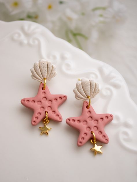 Drop Length: 1.4 in.Colors: Salmon colored Starfish with Cream Textured Shell Post Earring Hardware: 18k Gold-Plated flat postsCare instructionsPlease note that Wild Honey Clay earrings are handcrafted with polymer clay and must be handled with delicate care.Do not bend the earrings. Store them in their box when traveling to ensure protection & do not keep them in direct sunlight.Return PolicyWe do not accept returns or exchanges on our earrings. However, if one breaks due to a flaw in the design, we will send a replacement if it’s within two weeks of your purchase date. Polymer Clay Charm Earrings, Starfish Clay Earrings, Summer Clay Earring Ideas, Polymer Clay Ideas Jewelry, Polymer Clay Earrings Summer, Fimo Ideas Jewelry, Polymer Clay Earrings Diy Ideas, Disney Clay Earrings, Clay Earrings Design