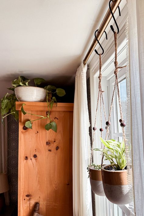 One of the easiest ways to update your bedroom decor is to add bedroom plants. Don't underestimate the power of plants!  Hanging plants from curtain rods is a fun way to add a touch of greenery and update your bedroom decor. Two of my favorite hanging plant varieties include pothos or string of pearls for a unique look. Check out our blog for more tips on updating your bedroom decor with plants. Your oasis awaits! Hanging Plant In Living Room, Plants Hanging From Curtain Rod, Inside Hanging Plants Ideas, Hanging Plants Over Window, Hanging Plant Indoor Ideas, Plants On Curtain Rod, Hang Plants In Window, Indoor Plant Hanging Ideas Diy, Hanging Indoor Plant Ideas