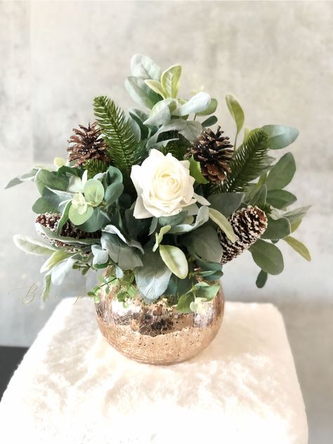 "Height: 15\" Width: 15\" Vase: 5\" golden glass bowl Christmas Artificial Flower Arrangement, Floral Faux Centerpiece, Natural and Real Touch Flowers in Glass Vase Home Decor *  Rustic Winter Greenery and Pinecone Rustic Mixed Floral Arrangements  * The arrangement contains the finest faux, real-touch white roses surrounded with plus winter greenery in a glass bowl.  * Lifelike winter greenery, arranged with white roses and cones in a golden round bowl vase, is a crafty artificial floral accent for your charming country décor.  * Add a spot of holiday happiness to your desk, powder room, and any neglected tabletop. * Makes an excellent gift! * The flowers feel so lovely, real, and lively, keep it for years to come! * At first look, people might not believe this is a permanent botanical de Flowers In Glass Vase, Winter Flower Arrangements, Winter Floral Arrangements, Paris Flowers, Winter Greenery, Christmas Flower Arrangements, Vase Home Decor, Arrangement Floral, Bowl Vase