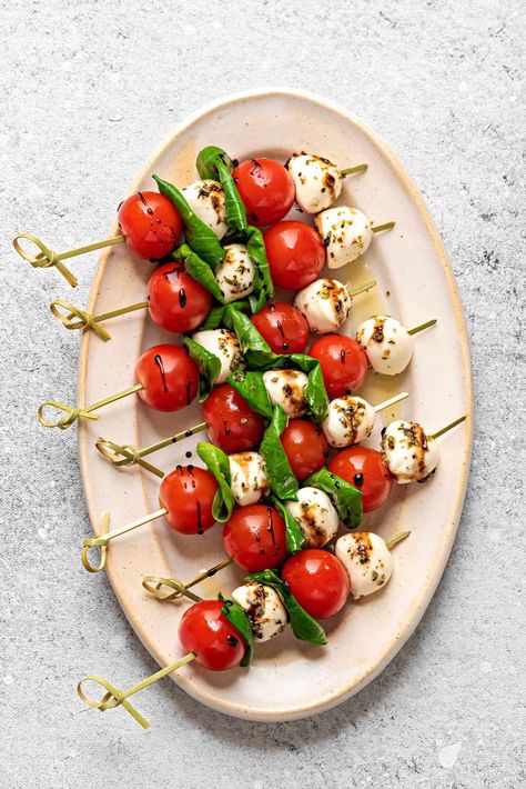 Caprese Salad Skewers Recipe - Handy Caprese skewers are a delicious and fun version of a classic Italian salad. This recipe is easy to make with mini tomatoes, mozzarella balls, fresh basil, and a flavorful balsamic reduction. Perfect for an effortless but impressive appetizer or healthy snack! | Cubes N Juliennes Mozzarella Balsamic Appetizer, Chicken Skewers Plating, Birthday Fruit Skewers, Tomato Caprese Skewers, Strawberry Caprese Skewers, Fruits Skewers Ideas, Party Appetizers Aesthetic, Blackberry Mozzarella Skewers, Bday Appetizer Ideas