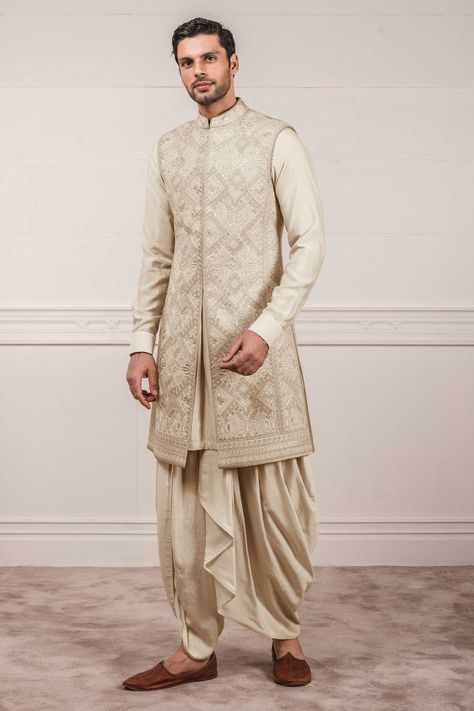 Featuring a gold sleeveless sherwani in katan silk and raw silk base with dori and aari embroidery. It is paired with a matching kurta and dhoti pants.  FIT: True to size. COMPOSITION: Katan silk, Raw silk. CARE: Dry clean only. Indo Western Outfits For Men, Dhoti Pants For Men, Indian Wedding Suits Men, Mens Indian Wear, Groom Dress Men, Wedding Outfits For Groom, Indian Groom Wear, Men's Wedding Outfit, Sherwani Groom