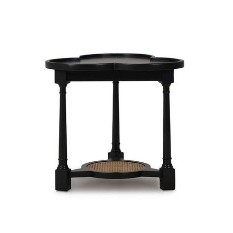 This unique side table features a solid wooden frame finished in our sleek Batavia black finish, providing both durability and a striking aesthetic. The table's clover-shaped top has a wooden gallery edge and adds a touch of elegance and charm, making it a standout piece in any room.  The lower woven rattan shelf offers additional storage and display space for your favorite decorative items. The turned legs enhance its classic appeal, seamlessly fitting into both contemporary and traditional int Rattan Shelf, Unique Side Table, Round End Tables, Black Rattan, Rustic Side Table, Post Lanterns, Bar Accessories Decor, Outdoor Ottomans, Side Table Wood