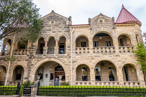 Limestone home with arches along the porch and balcony and red turrets on both ends Kerrville Texas Things To Do, Home With Arches, Kerrville Texas, Texas Vacation, Guadalupe River, Texas Vacations, Texas Roadtrip, Rv Road Trip, Porch And Balcony