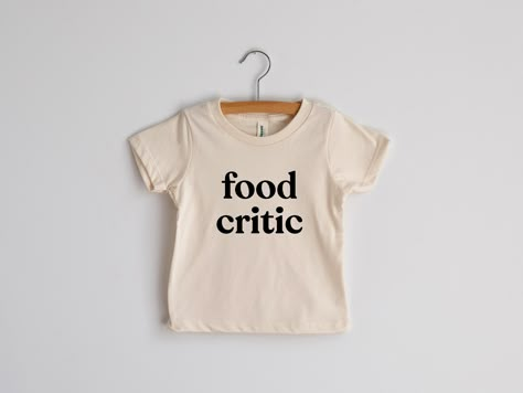 For wee ones with a refined and sophisticated palate! For wee ones with a refined and sophisticated palate! This modern tee for little ones features a fun, groovy typeface and was designed with love and screen printed by hand in-house in crisp black ink. Natural cream cotton is 100% organic. A funny outfit for picky eaters and tricky-to-feed toddlers. All artwork is original. Sizes available in: * 3-6 Months * 6-12 Months * 12-18 Months * 18-24 Months * 2T * 4T * 6T * Youth Small * Youth Medium Groovy Typeface, Toddler Graphic Tee, Kids Tee Shirts, Diy Shirts, Cool Kids Clothes, Food Critic, Organic Fabric, Kid Clothes, Graphic Sweaters