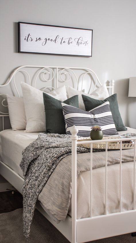 White & Grey Bedroom. Bedroom designed and styled with Ikea bedframe, toss cushions, & linens. Cozy and modern, great for a guest bedroom. Wall colour is Benjamin Moore Gray Owl. Airdrie, AB, Rocky View County, AB. eDesign. Leirvik Bedframe. #bedroomstyling #bedroomdesign #whitebedframe #ikeacanada #sparebedroomdecor #greendecor #grayowl #whtietosscushions #whitepillows #blackandwhite #blackandgrey #whiteandgrey #whiteandgreybedroom #whiteandgreenbedroom #greyandgreenbedroom #whitegreygreen Ikea Bedframe, Ikea Bedroom Ideas For Couples, White Grey Bedroom, Ikea Style Bedroom, Grey Green Bedrooms, White Iron Beds, Ikea Bedding, Ikea Bed Frames, White Metal Bed Frame