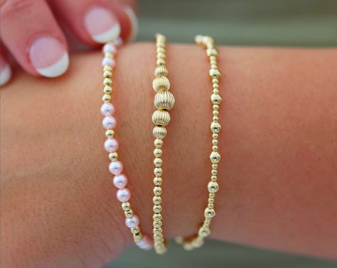 Waterproof | Tarnish Free | Hypoallergenic Bracelets: MELANIE ($49)- VICTORIA ($56)- ANGELINA ($46) Bead Material: Gold filled STRETCHY LENGTH: 6.5" OR 7" CLASP LENGTH: 6" + 1.5" EXTENSION High Performance Elastic Made in miami, made with love This stack is your ultimate accessory for effortless elegance and coastal chic. Inspired by the breezy sophistication of the Hamptons, these bracelets feature a collection of beautifully crafted ball beads in various sizes and colors, reminiscent of sun-ki Bracelets Stack, Gold Bracelets Stacked, Stack Bracelets, Preppy Bracelets, Preppy Jewelry, Coastal Charm, Jewelry Accessories Ideas, Rose Gold Pendant, Jewelry Essentials