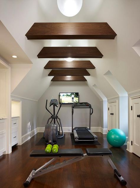 Attic home gym boasts a vaulted cieling adorned with wood beams placed over gym equipment facing a flat panel tv. Home Gym Closet, Attic Gym, Attic Space Ideas, Gym Closet, Attic Library, Attic Renovation Ideas, Finished Attic, Media Room Design, Yoga Ashtanga