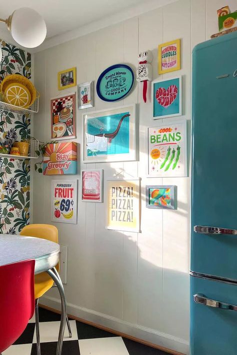 If you love gallery walls add one to your retro kitchen. This retro kitchen gallery wall is full of bright colors and positive feelings galore. We love that it matches the vibe of the colorful retro refrigerator! #BlueRetroFridge #KitchenIdeas #RetroKitchen #TheSpruce Retro Glam Kitchen, Vintage Maximalist Decor, Kitchen Glam, Refrigerator Decor, Retro Kitchens, Kitchen Gallery Wall, Retro Appliances, Diy Herb Garden, Retro Fridge