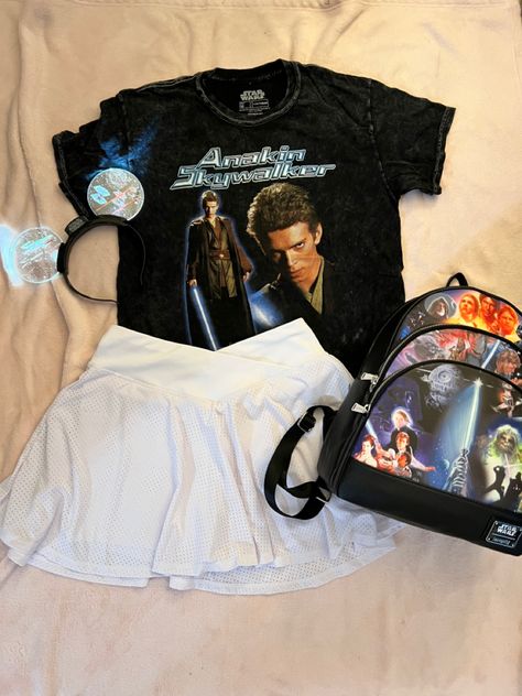 The picture consists of a black tshirt with a picture of Anakin Skywalker with his name written in a blue futuristic font. This is paired with a white skirt and light up Mickey ears that have Star Wars ships on them. Also pictured is a Star Wars Loungefly backpack with scenes from the movies. Star Wars Tshirt Outfit, Starwars Outfits For Disney, Disneyland Outfits Star Wars, Hollywood Studios Outfit Star Wars, Starwars Outfit Ideas, Disney Outfits Skirt, Universal Studios Orlando Outfits, Disney World Star Wars Outfits, Disneyland Star Wars Outfit