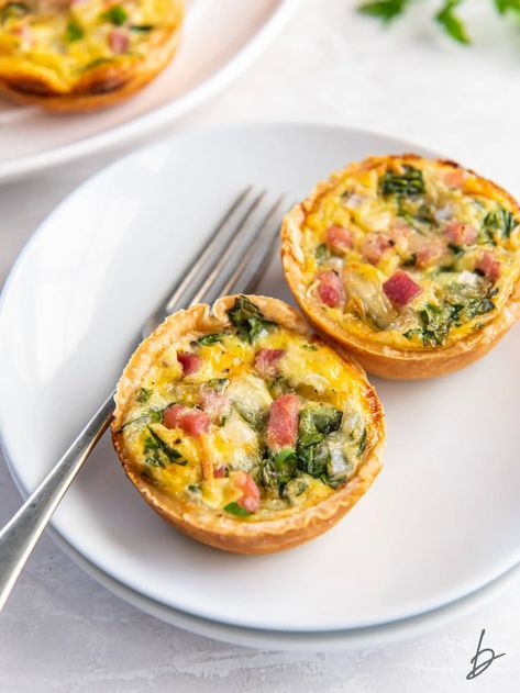 two muffin tin quiches on a white plate with a fork. Muffin Tin Quiche, Breakfast Quiche Muffins, Mini Quiche Recipes, Quiche Muffins, Breakfast Quiche Recipes, Mini Quiches, Breakfast Quiche, Quiche Recipe, Mini Quiche