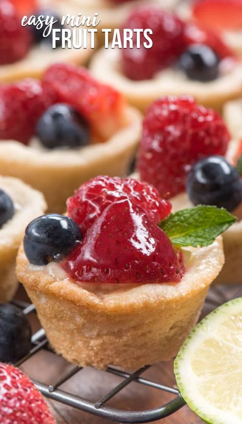 These easy mini Fruit Tarts start with a sugar cookie cup and are filled with a no bake cheesecake and topped with fresh berries and a lime glaze. Make them easy by starting with a prepared sugar cookie dough! Fruit Tart Recipe Mini, Fruit Tart Recipe Easy, Mini Tart Recipes, Mini Quiche Recipes, Easy Tart Recipes, Mini Fruit Tarts, Fruit Tart Recipe, Fruit Tarts, Mini Tart