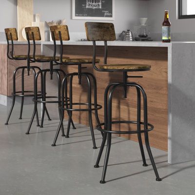 Redefine industrial style with this 4-piece set of adjustable-height bar stools. Each one features a 360° swivel for easy access to snacks, the remote control, or the nearest conversation. A striking black-finished iron frame includes four streamlined legs and a circular footrest for your convenience. The round seats and low backs are made from engineered wood with a rustic brown finish. A noticeable wood grain brings back a vintage-inspired style we just love. Some assembly is required, and eac Farmhouse Bar Stools, Rustic Bar Stools, Bar Stools Kitchen Island, Vintage Bar Stools, Industrial Bar Stools, Stools For Kitchen Island, 30 Bar Stools, Bar Stools With Backs, Industrial Bar