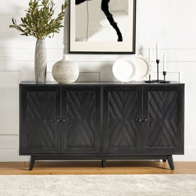 This mid-century-inspired sideboard brings plenty of vintage charm to your living room or dining area. The frame is made from engineered wood with a rustic finish, and it showcases a chevron-patterned inlay on the front with contrasting dark handles. With four doors and three adjustable shelves, it offers versatile storage solutions to accommodate your needs. The poplar wood legs with adjustable feet not only add to its retro appeal but also help keep it level. Designed to hold up to a 70" flats Black Sideboard Buffet, Mid Century Entryway, Sophisticated Casual, Wide Sideboard, Black Sideboard, Sideboard Furniture, Large Drawers, Sideboard Buffet, Adjustable Shelves