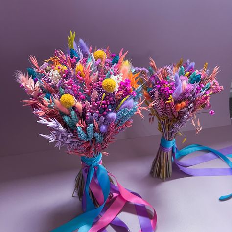 Introducing our Vibrant Dried Flower Bouquet, a top-seller renowned for its stunning array of colors, primarily featuring rich shades of purple, blue, and pink with berry undertones. This bouquet is an ideal choice for couples seeking a bohemian, whimsical, or LGBTQ+ pride-themed wedding, as well as those embracing a bright and colorful wedding palette. 🌈 Our bouquet showcases a lively assortment of premium dried flowers carefully selected and artfully arranged to create a breathtaking visual d Nontraditional Bouquet Wedding, Creative Wedding Bouquets, Dry Flower Wedding Bouquet, Colorful Prom Bouquet, Color Wedding Bouquets, Rainbow Wedding Centerpieces, Rainbow Flower Bouquet, Wedding Bouquets Colorful, Purple Spring Wedding