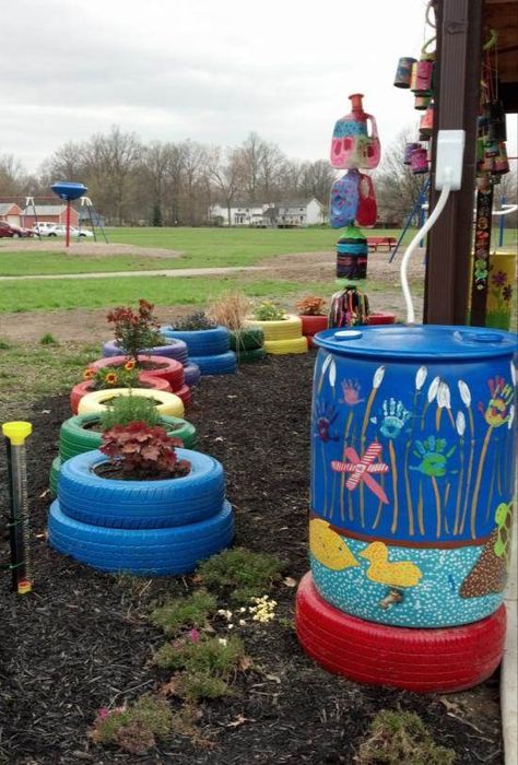 Rain Barrel at Grant Elementary School---LOVE THE PAINTED TIRE UNDER THE RAINBARREL! Elementary Courtyard Ideas, School Garden Club Ideas, School Gardening Club Ideas, Eco Projects For School, Elementary Playground Ideas, Rain Barrel Art, Sensory Gardens For Schools, School Gardens Elementary, School Courtyard Ideas