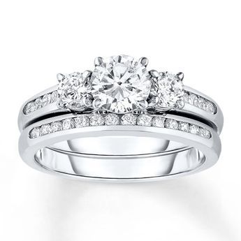 I love this one!!! Three magnificent round diamonds dazzle at the center of her engagement ring as part of this thrilling bridal set. Sparkling round white diamonds are channel set into the band of the engagement ring as well as the matching wedding band. The bridal set is styled in 14K white gold and has a total diamond weight of 1 3/8 carats. Diamond Total Carat Weight may range from 1.37 - 1.44 carats. Wedding Ring Sets Round, Engagement Rings Wedding Bands Set, Wedding Rings Round, 3 Stone Engagement Rings, Engagement Wedding Ring Sets, Three Stone Diamond, Bridesmaid Jewelry Sets, Three Stone Engagement, Wedding Band Sets