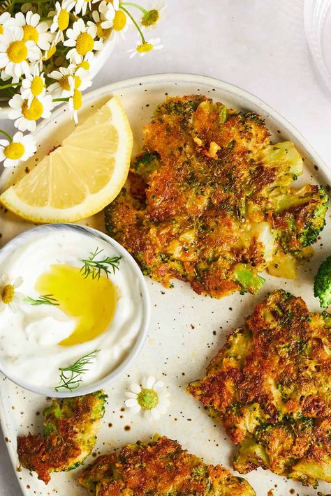 A plate of cheesy broccoli fritters with dipping sauce.