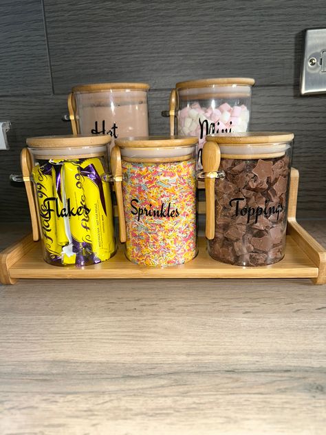 price is slightly cheaper on our website. thecustomisationcompany.com  Our Hot Chocolate Station is perfect addition to your kitchen.  5 glass jars with bamboo lids and spoons on a tiered shelf.  2 jars at the back 0.8 litres H 12cm D 9.5cm  3 front jars 0.5 litres H 12 lcm D 8cm.  Two tiered bamboo shelf H 7cm W 21.5cm  L 32cm.  Jars can have anything written on them , or can be left blank so you can switch what you put in them. Text colour options are Black, White, Grey, Brown. Small Hot Chocolate Station, Coffee Station Ideas Bedroom, Diy Hot Chocolate Station, Autumn Coffee Station, Hot Chocolate Bar Set Up, Cereal Station At Home, Bar Armoire Ideas, Drink Station Ideas Kitchens, Coffee Bar Armoire Ideas