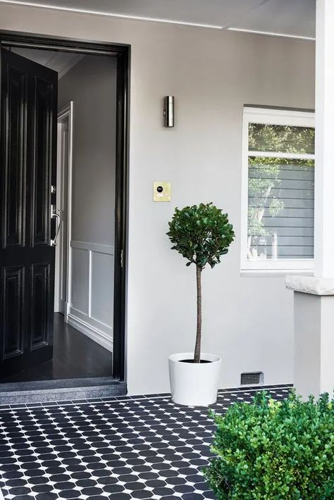 a very laconic and simple modern porch with a black door, black and white patterned tiles, some potted greenery is a chic idea to repeat Tiled Entrance, Tessellated Tiles, Modern Front Porch Decor, Modern Front Porches, Front Door Interior, Front Verandah, Modern Porch, Porch Tile, Exterior Wall Tiles