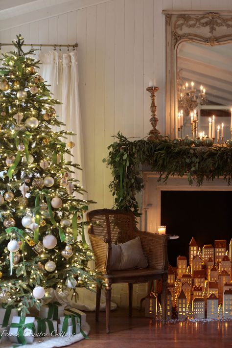 a decorated christmas tree in front of a fireplace