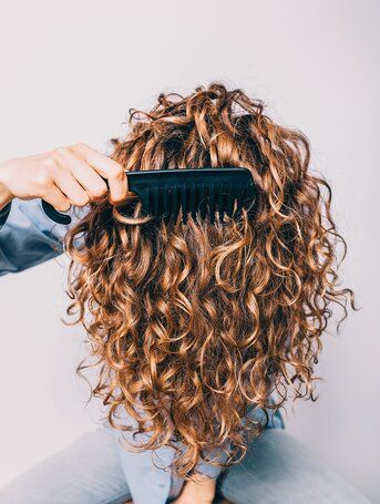 woman-combing-curly-hair-getty-1119 Comb For Curly Hair, Natural Curly Hair Cuts, Curly Hair Problems, Hair Damage, Curly Hair Inspiration, Coily Hair, Celebrity Hair Stylist, Types Of Curls, Curly Hair Tips