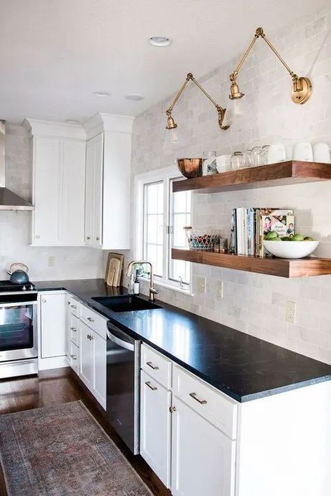 a white farmhouse kitchen with shaker cabinets, black soapstone countertops, a neutral tile backsplash and open shelving Black Countertops Kitchen, White And Black Kitchen, Kitchen Black Counter, White Cabinets Black Countertops, Home Painting Ideas, Plants Kitchen, White Cabinets White Countertops, Black Kitchen Countertops, Black And White Kitchen