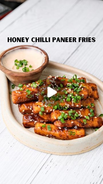 Mahima Dhoot on Instagram: "Honey Chilli Paneer Fries

Fries that are spicing up my Indo-Chinese food obsession 🌶️🍟 Tangy, crispy, and absolutely mind-blowing. It’s like a flavor explosion in every bite, and I’m so here for it. For someone who can’t get enough of Indo-Chinese flavors, this is next-level delicious! 🍜✨

Recipe: 
-cut the 150g paneer into long fries as shown in the video
-take 2 tbsp corn flour in a bowl, add some salt and coat the panner fries in it nicely, and fry them. (You can also air fry or pan fry) 
-for the sauce, add 1 tsp oil, 2 garlic cloves grated, 1 tbsp soy sauce, 2 tbsp chilli sauce (I used sriracha) and 1 tsp honey in a pan & mix it 
-toast your panner in the sauce, coat it well and serve it hot with some spring onions & sesame seeds on top

Dining With Dho Chilli Paneer Recipe Video, Long Fries, Chilli Paneer, Pan Fry, Corn Flour, Spring Onions, Paneer Recipes, Chilli Sauce, Cooking Class